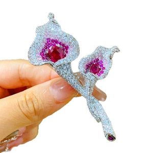 Sparkling calla lily brooch with red cubic zirconia and white pavé crystals on hand