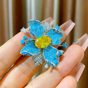 Broche magnétique fleur élégante avec pétales bleus et zircone jaune au centre