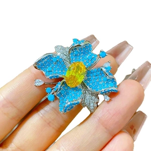 Broche magnétique florale élégante avec une pierre jaune et des pétales bleus