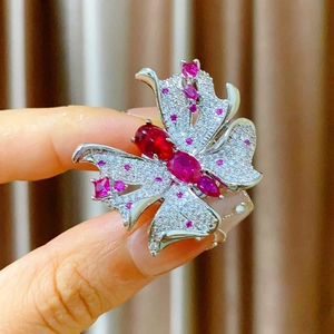 Détail macro d'une broche papillon aimantée avec rubis rouges et zircons violets