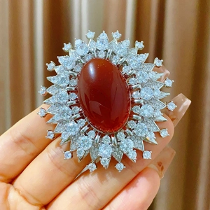 Macro detail of royal vintage sunburst brooch with oval red agate and zircon stones