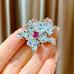 Handgehaltene florale Brosche mit Zirkonia, rotem Kristall und blauen Akzenten