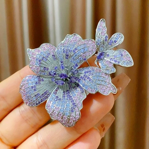 Dettaglio macro della spilla orchidea con zirconi viola e rosa su base argento