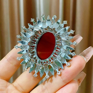 Close-up of vintage oval red agate brooch with silver alloy base and crystal detailing