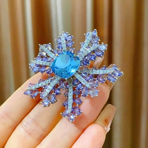 Broche flocon de neige luxueuse avec pierre bleue centrale et accents violets sur argent