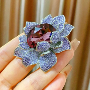 Macro d'une broche lotus de luxe avec pierre violette et pétales de cristal