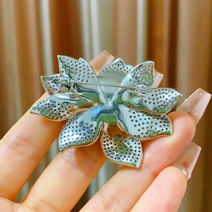 Vue arrière détaillée de la broche lotus montrant le fermoir et le motif ajouré