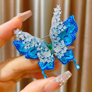 Vista detallada del broche de mariposa de lujo con esmalte azul y gemas de circonio