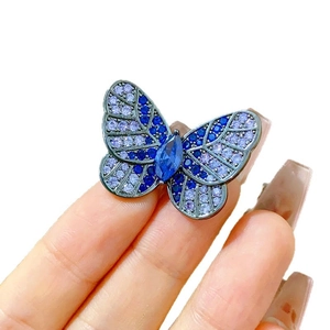 Exquisite butterfly brooch with purple and blue crystals on a dark metal base