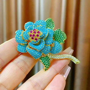 Elegante spilla a fiore dorata con gemme blu e rosa per giacche e abiti formali