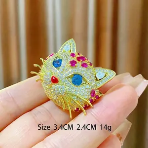 Élégante broche tête de chat en métal doré avec zircones et yeux en pierres bleues