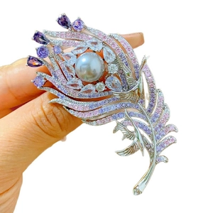 Intricate peacock feather brooch with purple zircons and a grey pearl inlay