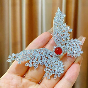 Elegant butterfly brooch with red zircon and crystal wings held in hand
