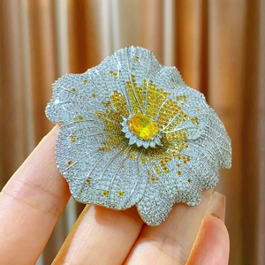 Macro della spilla a girasole in argento con zircone giallo ovale e micro-pavé di cristalli
