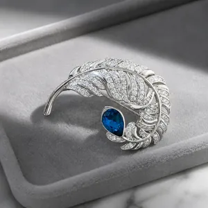 Elegant silver feather brooch with light blue crystal teardrop and sparkling pavé crystals