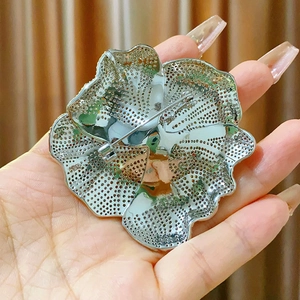 Dettaglio del retro di una spilla girasole argento con trama a rete e chiusura a spilla