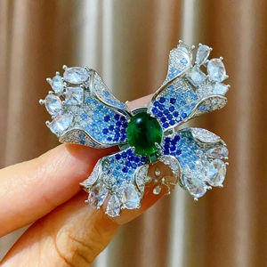 Broche papillon de luxe avec pierre centrale verte et pavé de zircone en dégradé bleu