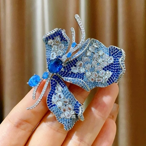 Luxuriöse Schmetterlingsbrosche mit blau-weißen Zirkonia-Steinen in der Handansicht