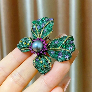 Elegant floral brooch with grey pearl and colorful zircon stones held in hand
