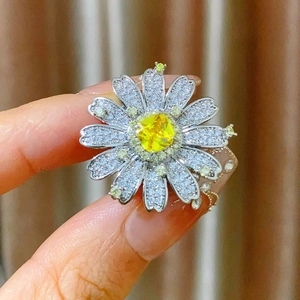 Dettaglio anello a margherita con gemma gialla e petali di cristalli bianchi brillanti