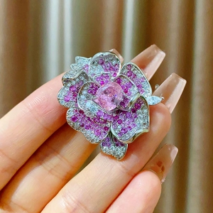 Macro shot of 3D camellia flower brooch with pink crystals and silver-tone petals