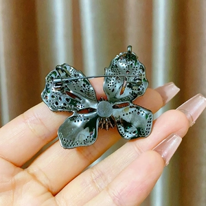 Detailed back view of a butterfly brooch showing secure pin fastener and metal hollow craft
