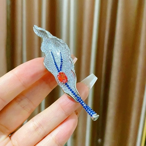 Elegant leaf brooch with sparkling zircons and orange center stone for formal wear