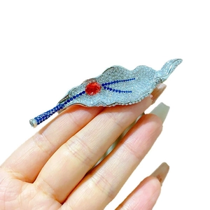 Elegant leaf brooch with sparkling diamonds and red ruby center for evening gowns
