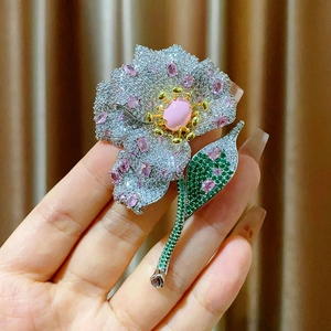 Elegant floral brooch featuring pink gems and white zircons on silver metal base