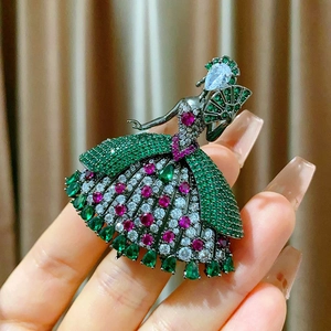 Detalle de broche de bailarina de lujo con cristales verdes y rosas vibrantes