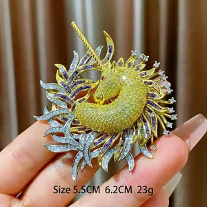 Broche licorne de luxe dorée ornée de pierres jaunes et détails de plumes violettes