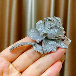 Dettaglio macro di una lussuosa spilla a rosa con zirconi su una base d'argento