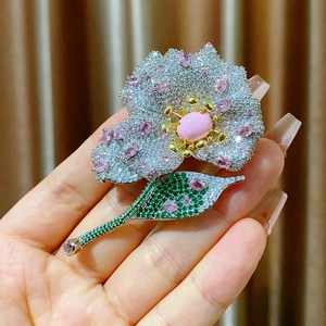 Luxurious flower brooch with micro-pave zircons and pink gemstones on elegant gold base