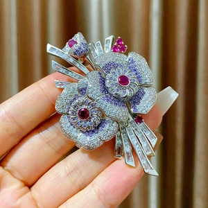 Détail de la broche fleurie avec cristaux violets et pierre précieuse rouge au centre