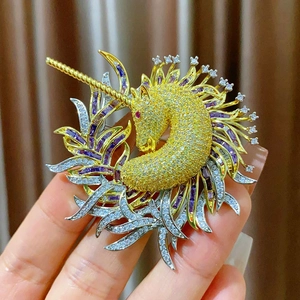 Exquise broche licorne dorée ornée de cristaux zircons jaunes et pierres violettes
