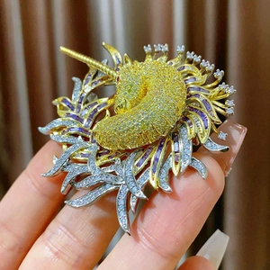Broche licorne élégante sertie de cristaux jaunes et violets avec pompons dorés