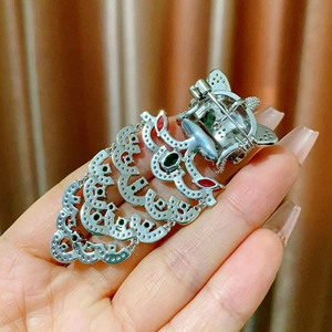 Detailed back view of a Chinese style lion dance brooch with silver fringe and gemstones