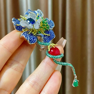 Dettaglio della spilla a peonia con zirconi blu ed elegante nappa di pietre preziose verdi