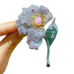 Luxury flower brooch with pink gemstones and pavé crystals on silver metal base