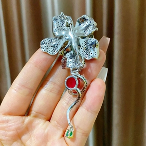 Dettaglio del retro di una spilla floreale in argento con chiusura a perno e gemme