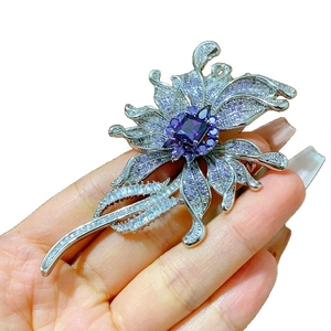 Elegant floral brooch with purple stones and zircon tassels on a silver base