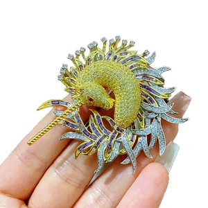Broche licorne exquise avec cristaux colorés et glands dorés sur un fond blanc neutre