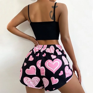 Women's 2-piece pajama set with pink heart print shorts and black tank top from behind