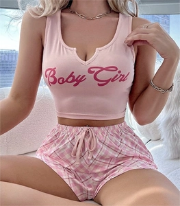 Détail du haut rose avec lettrage Baby Girl et short de pyjama à carreaux