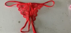 Detailed view of red lace G-string panties with delicate bow accents and open crotch