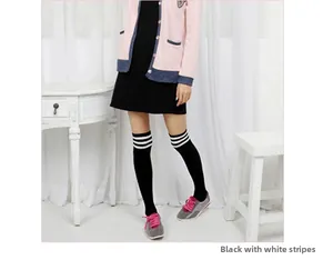 Detail of black over-the-knee socks featuring three white stripes at the top opening