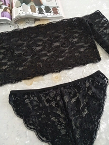 Vue à plat d'un ensemble de lingerie en dentelle florale noire avec bords festonnés