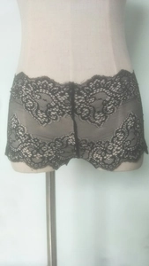 Close-up of black lace boyshorts featuring intricate floral mesh and delicate eyelash lace trim