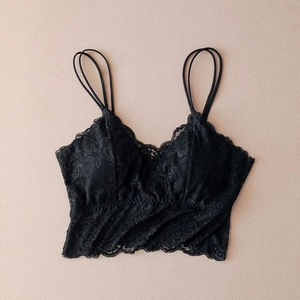 Detail view of black floral lace camisole with thin double straps and scalloped edges