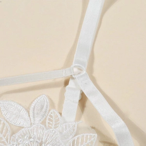 Dettaglio del ricamo in pizzo bianco e spalline regolabili della lingerie sexy